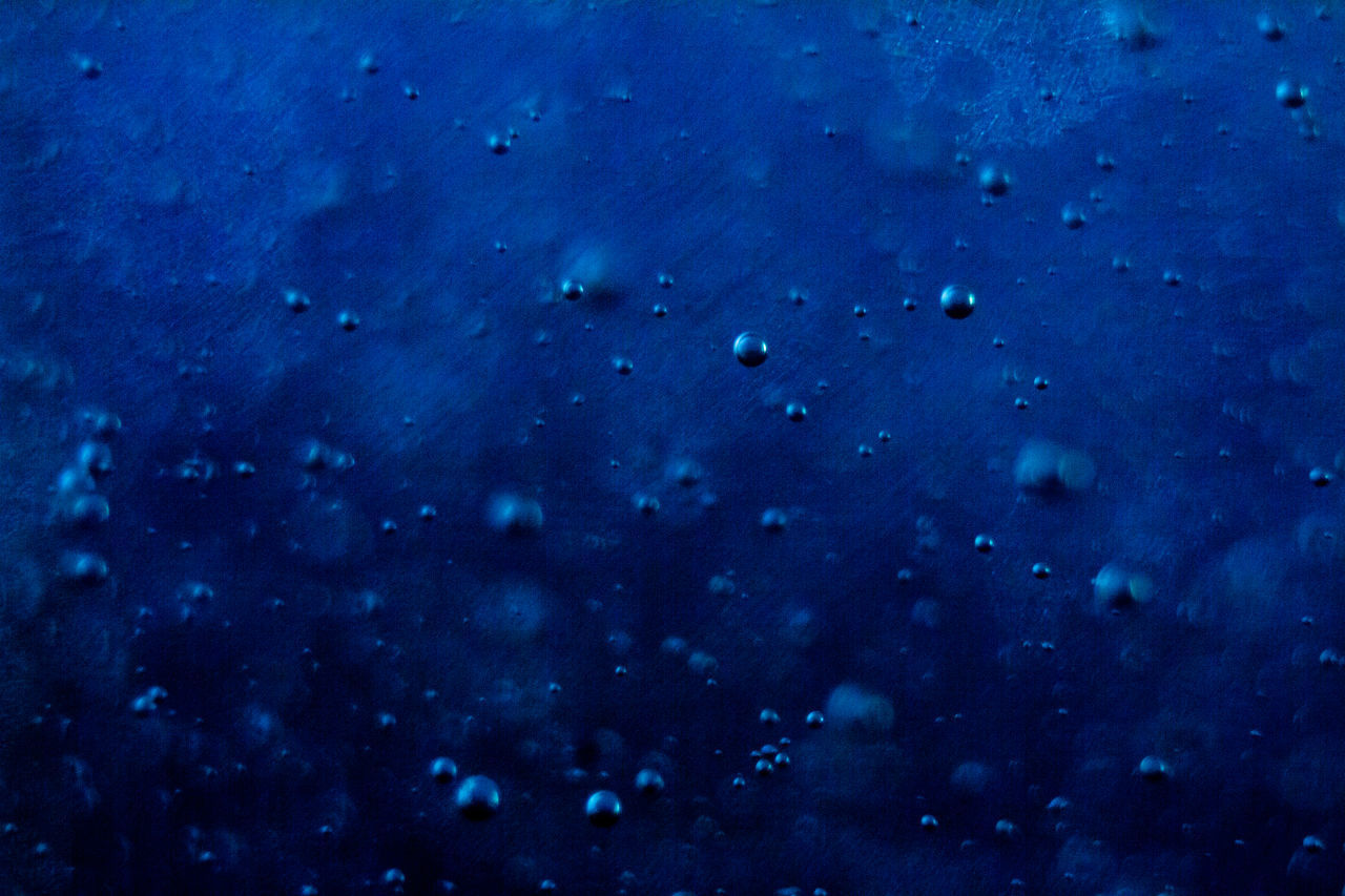 CLOSE-UP OF RAINDROPS ON GLASS WINDOW