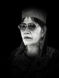 Portrait of mature woman against black background