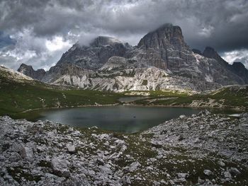 Scenic view of lake and mountains against cloudy sky