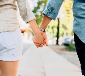 Midsection of couple holding hands