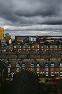 High angle view of buildings in city against cloudy sky