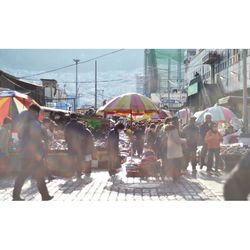 People walking in city against clear sky