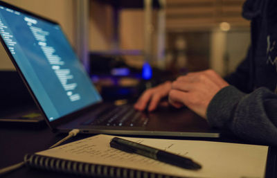 Cropped hand of woman using laptop