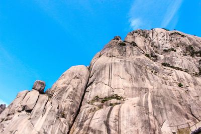 Low angle view of rock formation against clear blue sky