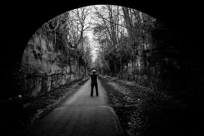 Man photographing by arch tunnel road