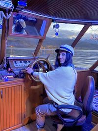 Rear view of man sitting on boat