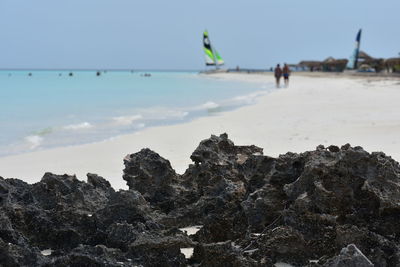 Scenic view of rocks on beach against clear sky