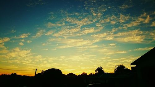 Low angle view of silhouette trees against sky