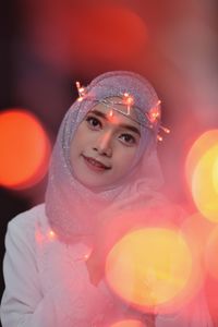 Portrait of young woman wearing illuminated lights