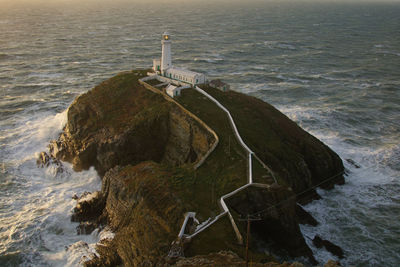 High angle view of lighthouse by cliff