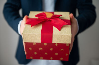 Close-up of hand holding red flower in box