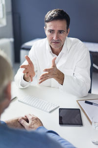 Serious doctor talking to patient in medical practice