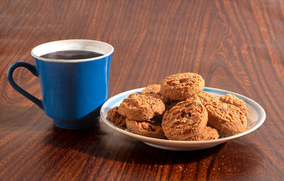 Chocolate chip cookies on a saucer and a cup of coffee