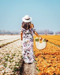 Rear view of woman walking on field