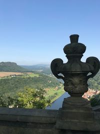 Cross on landscape against clear sky