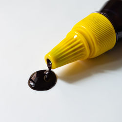 Close-up of yellow light bulb over white background