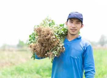 Portrait of smiling young man standing on field