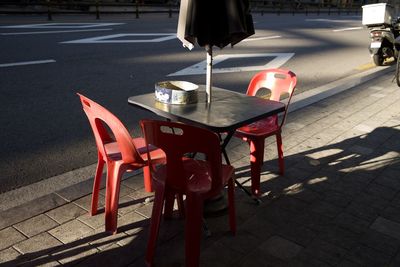 Empty seats on sidewalk in city