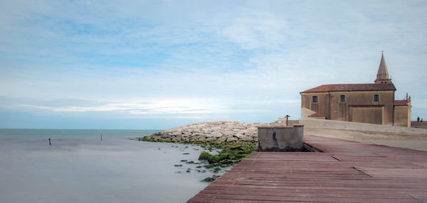 Scenic view of sea by building against sky