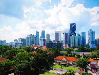 Buildings in city against cloudy sky