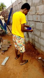 Full length of a boy standing against wall