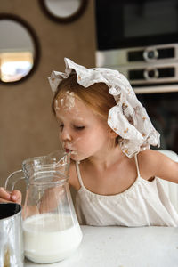 Little girl cooking pizza in the kitchen