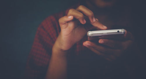 Midsection of man using mobile phone