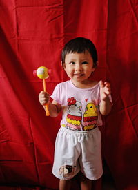 Portrait of cute boy holding red umbrella