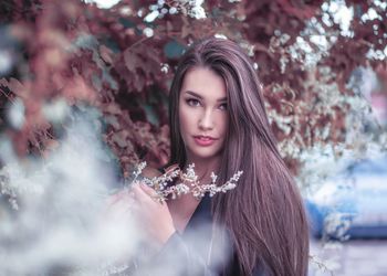 Portrait of beautiful woman against plants