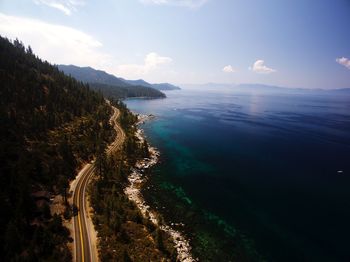 Aerial view of road by sea against sky