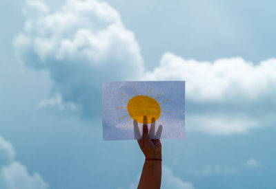 Person holding umbrella against sky