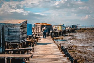 Rear view of man standing on walkway against sky