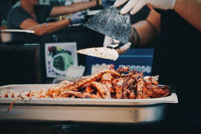 Midsection of man preparing food in market