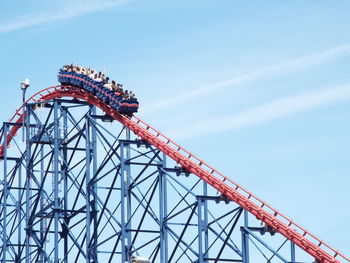 Low angle view of people enjoying big one ride at blackpool pleasure beach against sky
