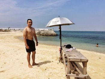 Portrait of young man standing on beach