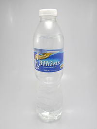 Close-up of glass of bottle against white background