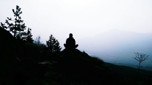 Silhouette man on mountain against clear sky