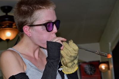 Close-up of woman glass blowing at home