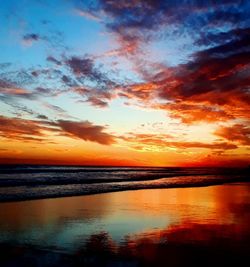 Scenic view of sea against dramatic sky during sunset