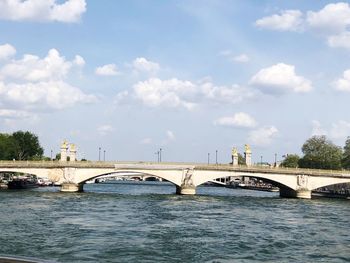 Arch bridge over river against sky