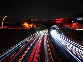 Light trails on bridge in city at night