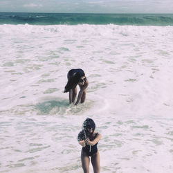 Multiple image of woman playing in sea