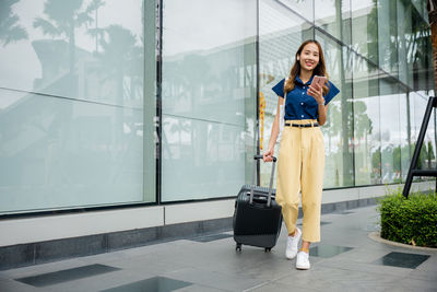 Portrait of young woman standing in city