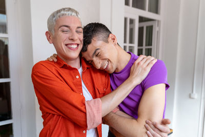 Portrait of happy young gay couple in love while they hug