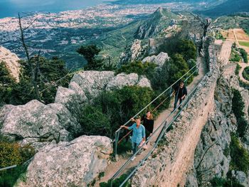 High angle view of friends walking on bridge against mountains