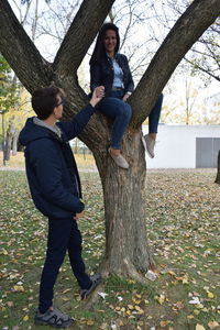 Full length of men on tree trunk