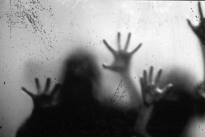 Shadow of woman hand on glass window
