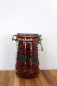 Close-up of glass jar on table against white background