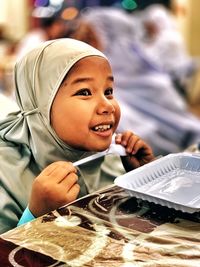 Smiling girl looking away while sitting at table