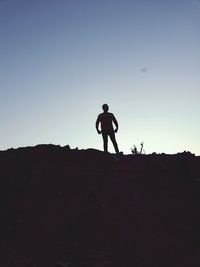 Silhouette man standing on field against clear sky